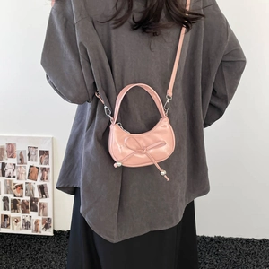 Sac croissant en cuir verni rose avec nœud décoratif et perles argentées