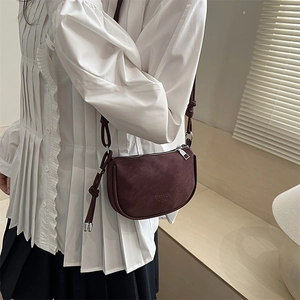Minimalist burgundy crossbody bag with bow shoulder strap and brand logo engraving