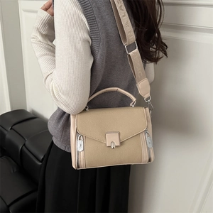 Minimalist beige crossbody bag with wide strap and square metal buckle on white background
