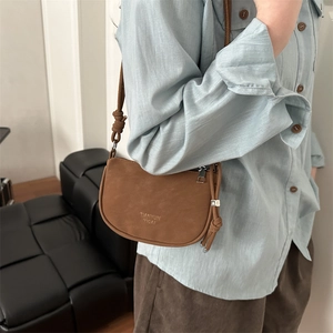 Brown semi-circular crossbody bag in suede finish with adjustable knotted strap for women