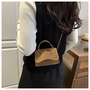 Mini sac bandoulière en cuir marron mat présenté de dos sur un modèle élégant