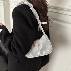 Borsa sottobraccio plissettata argento con fiocco dorato e tracolla arricciata