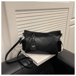 Detail view of the black matte leather shoulder bag with side pockets and a fashion tag