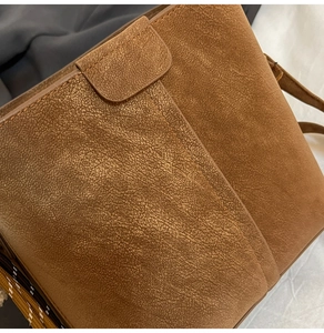 Detail aus braunem Leder mit Lychee-Muster und feiner Naht an der Vintage-Tasche