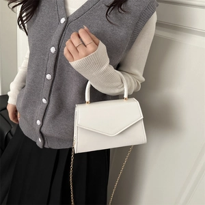 Minimalist white envelope flap square bag with top handle and gold chain strap for women