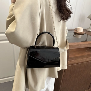 Chic black patent leather mini crossbody bag with gold chain strap and envelope flap