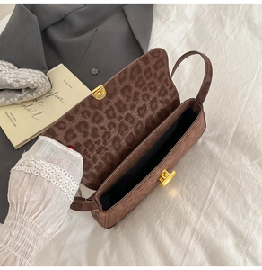 Macro detail of brown leopard print underarm bag with gold twist lock and velvet texture