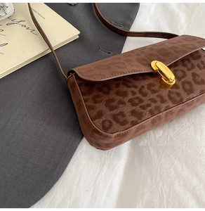 Close-up of leopard print shoulder bag with elegant gold oval twist lock closure