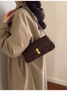 Detail shot of vintage dark leopard print suede shoulder bag with golden twist lock clasp
