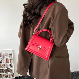Sac à main rouge élégant avec poignée torsadée dorée et design à rabat texturé