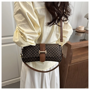 Dettaglio di una borsa a tracolla vintage a quadri con fibbia dorata su modella