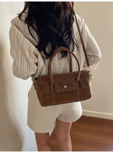 Brown handbag with contrast stitching, silver buckle and round handles on model