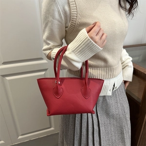 Minimalist red leather bucket handbag with litchi texture shown by model