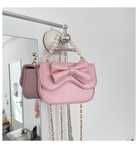 Pink leather mini bag with bow detail, pearl handle and gold chain strap close-up