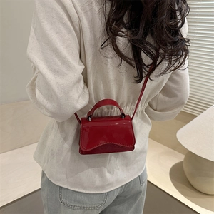 Minimalist red patent leather mini square handbag with top handle and crossbody strap