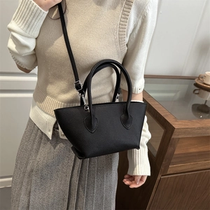 Minimalist black lychee leather bucket bag with dual handles and silver hardware