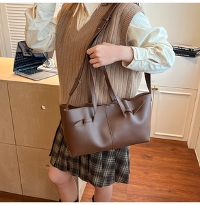 Close-up of the stylish knotted handle detail on this soft brown leather tote bag