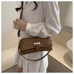 Dettaglio borsa a tracolla vintage marrone con fibbia metallica dorata a forma di H