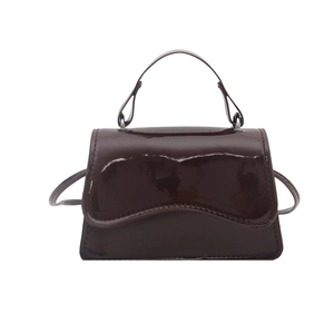 Minimalist dark brown patent leather handbag with wavy flap and adjustable shoulder strap