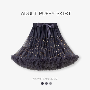 Détail d'un jupon noir multicouche avec motifs d'étoiles dorées et nœud en satin