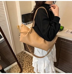 Detail view of khaki leather tote bag featuring unique knot pleats and soft texture finish