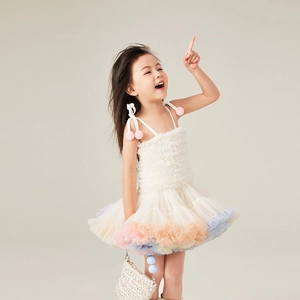 Detail of girls' rainbow tulle tutu dress with pink pom-pom straps and gradient mesh layers