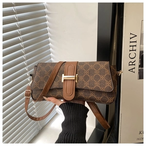 Dettaglio della borsa a tracolla marrone vintage con stampa trifoglio e fibbia dorata a H