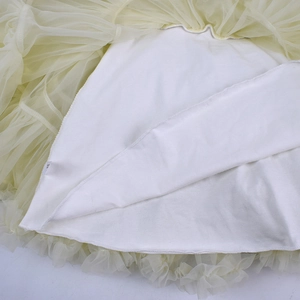 Close-up of baby tutu skirt showing skin-friendly white lining and multi-layer yellow mesh