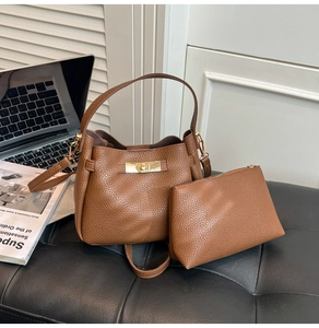 Detail of brown litchi pattern bucket bag and matching pouch on an office desk