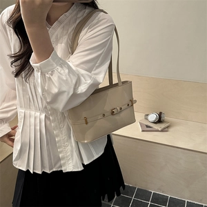 Minimalist beige leather tote bag with buckle strap detail for stylish urban commuting