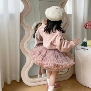 Detail of pink knitted sweater and layered tulle tutu skirt for little girls