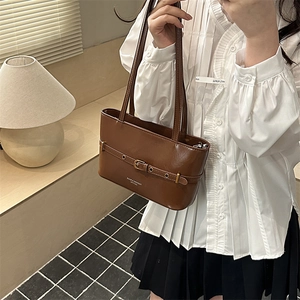 Brown leather tote bag with decorative buckle detail shown as a stylish shoulder underarm bag