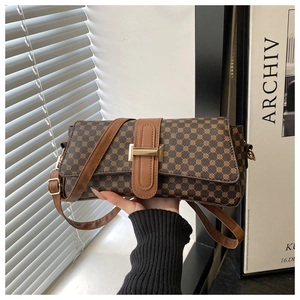 Dettaglio borsa a tracolla vintage marrone con motivi geometrici e fibbia in metallo oro