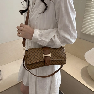 Borsa a tracolla marrone con motivo geometrico e fibbia H dorata su abito bianco