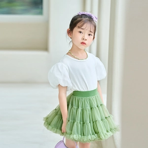 Girls fashion outfit featuring a white puff sleeve top and green layered tulle tutu skirt