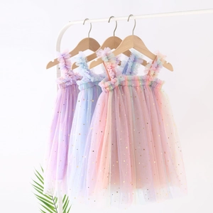 Detail of girls' rainbow tulle dresses with shimmering gold star and moon patterns