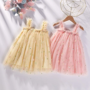 Détail de deux robes en tulle pour filles avec broderie marguerite en jaune et rose doux