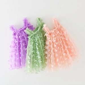 Detailed view of girls' tulle dresses with 3D butterfly appliques in three soft colors