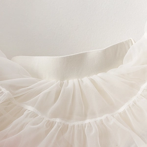 Detail shot of white multilayered tulle tutu skirt with soft mesh ruffles and stitching