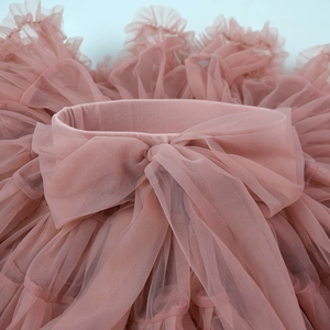 Detailed close-up of layered mesh tutu skirt with a decorative pink tulle bow