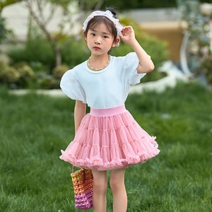 Close-up of girls pink layered mesh tutu skirt with white knit puff sleeve t-shirt