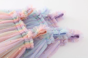 Detail of rainbow mesh tutu dress with golden star sequins and ruffled straps