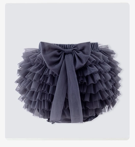 Detail of multi-layered dark grey blue tutu skirt with a large decorative fabric bow