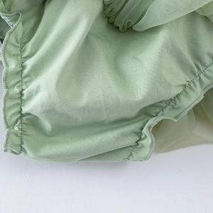 Détail macro du tissu en maille vert clair et des bords élastiques à volants