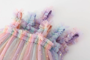 Detail of rainbow tulle layers with gold foil star and moon patterns on girls' dress