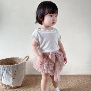 Detail showing the pink layered tutu skirt with a mesh bow and knitted top texture