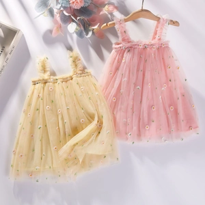 Détail de tulle brodé de marguerites sur robes à bretelles avec volants aux épaules