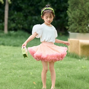 Detailed view of girls white puff sleeve cotton tee paired with pink layered tutu skirt