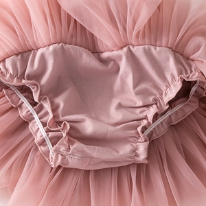 Détail d'une jupe tutu rose pour bébé avec couvre-couche intégré et volants élastiques
