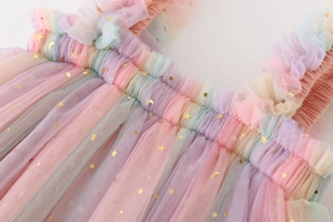 Close-up of rainbow gradient tulle fabric with gold foil star and moon patterns
